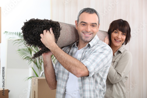 Photo: Couple carrying rug Couple carrying rug