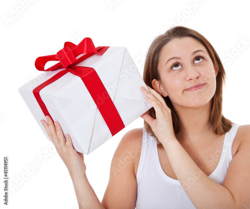 Photo: Mädchen schüttelt sanft ein Geschenk Mädchen schüttelt sanft ein Geschenk