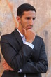 Cool young man standing at the street and thinking