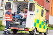 Paramedics putting patient in ambulance car aid
