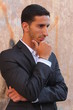 Cool young man standing at the street and thinking