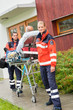 Paramedics with patient on stretcher ambulance aid