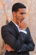 Cool young man standing at the street and thinking