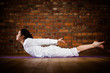 Woman exercising yoga against brick wall