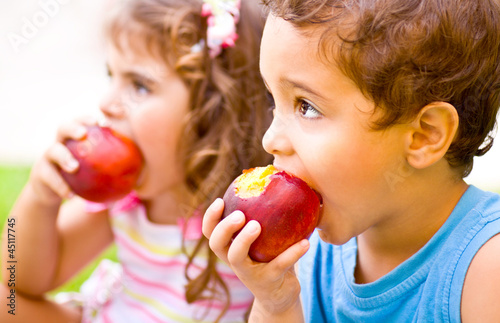 Photo: Happy children eating apple Happy children eating apple