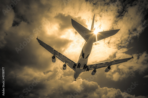 Photo: passenger jet landing through golden clouds passenger jet landing through golden clouds