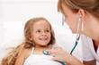 Little girl in bed having a health check