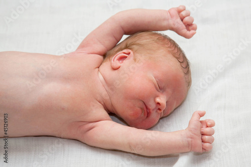 Photo: Peacefully and soundly sleeping naked newborn tiny slim baby Peacefully and soundly sleeping naked newborn tiny slim baby