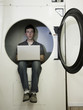 man inside a commercial clothes dryer at a laundromat
