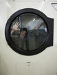 man inside a commercial clothes dryer at a laundromat