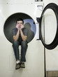 man inside a commercial clothes dryer at a laundromat