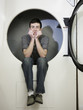 man inside a commercial clothes dryer at a laundromat