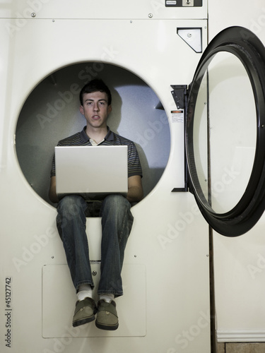 Photo: man inside a commercial clothes dryer at a laundromat man inside a commercial clothes dryer at a laundromat