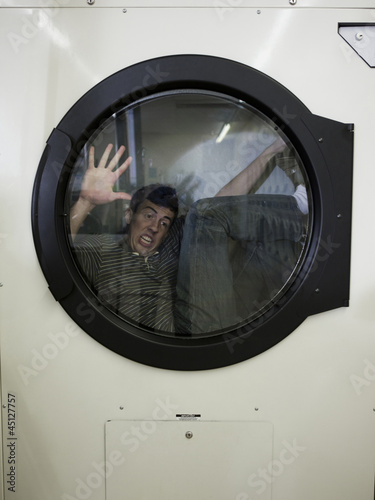 Photo: man inside a commercial clothes dryer at a laundromat man inside a commercial clothes dryer at a laundromat