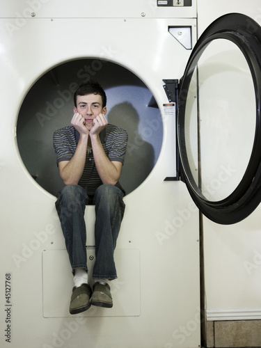 Photo: man inside a commercial clothes dryer at a laundromat man inside a commercial clothes dryer at a laundromat