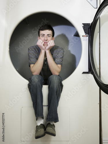 Photo: man inside a commercial clothes dryer at a laundromat man inside a commercial clothes dryer at a laundromat