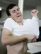 man putting on a shrunken t-shirt