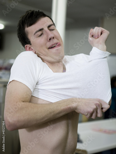 Photo: man putting on a shrunken t-shirt man putting on a shrunken t-shirt