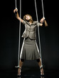 businesswoman being pulled by strings like a puppet