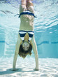 teenage girl doing a handstand under water