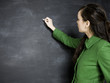 Photo : young woman writing on a chalkboard young woman writing on a chalkboard