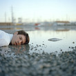 "USA, Utah, Salt Lake City, Dead man lying in puddle with dead fish"