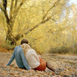 Photo: "USA, Utah, Salt Lake City, Young couple sitting together in autumn park, rear view" "USA, Utah, Salt Lake City, Young couple sitting together in autumn park, rear view"