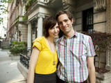 Photo: "USA, New York, New York City, Portrait of young couple in front of apartment building" "USA, New York, New York City, Portrait of young couple in front of apartment building"