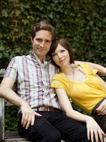 Photo: "USA, New York, New York City, Portrait of young couple on park bench" "USA, New York, New York City, Portrait of young couple on park bench"