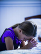 girl praying by her bed