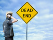 man looking at a dead end sign