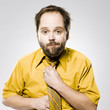 man in a yellow shirt and tie fixing his tie
