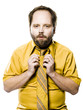 man in a yellow shirt and tie fixing his tie