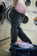 man putting on jeans at the laundromat