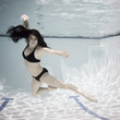 woman swimming underwater in a pool