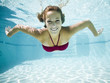 teenage girl in a bathing suit swimming in a pool