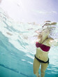 teenage girl in a bathing suit swimming in a pool