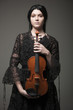 Studio portrait of young woman holding violin