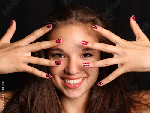 Photo: Mädchen lächelt durch Hände hindurch Mädchen lächelt durch Hände hindurch