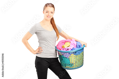 Photo: Young smiling woman holding a laundry basket full of clothes Young smiling woman holding a laundry basket full of clothes