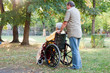 Rollstuhlfahrerin mit Betreuer im Park