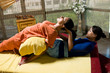 Asian woman Thai massaging beautiful adult woman at spa salon