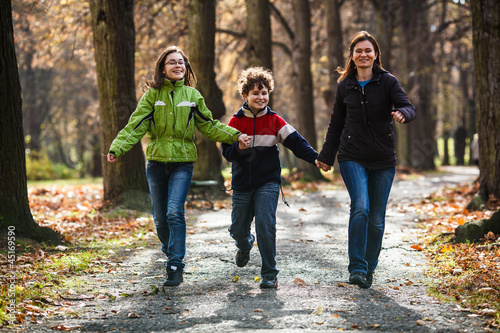 Photo: Active family - mother and kids walking, running outdoor Active family - mother and kids walking, running outdoor