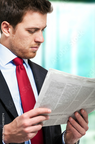 Photo: Business man reading a newspaper Business man reading a newspaper