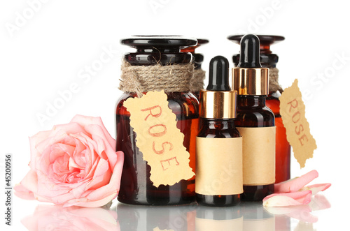 Photo: bottles of oil and roses isolated on white bottles of oil and roses isolated on white
