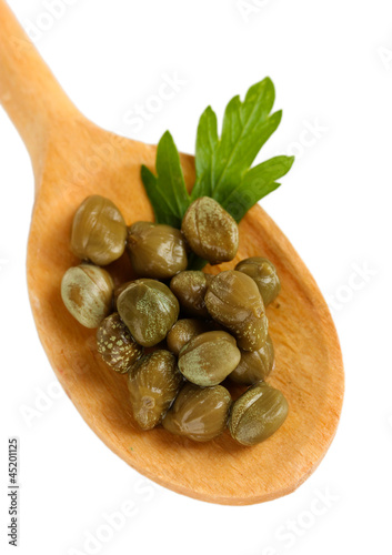 Photo: green capers in wooden spoon on white background close-up green capers in wooden spoon on white background close-up