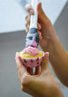 Frisch gebackene Muffins werden mit Zuckerguss glasiert