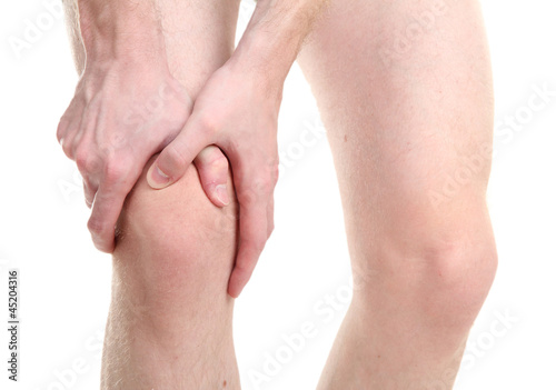 Photo: man holding sore knee, isolated on white man holding sore knee, isolated on white
