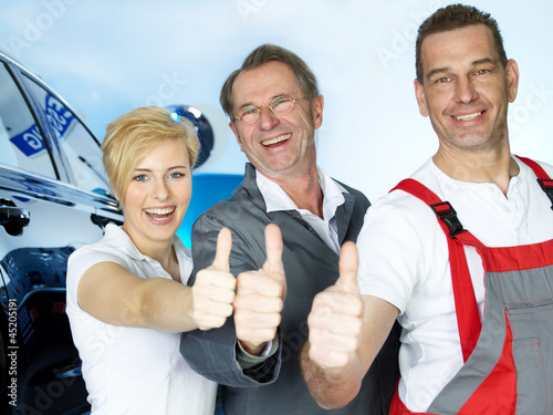 Photo: Team of car mechanics show thumbs up for good teamwork Team of car mechanics show thumbs up for good teamwork