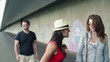 Three people walking along wall with graffiti, steadicam shot